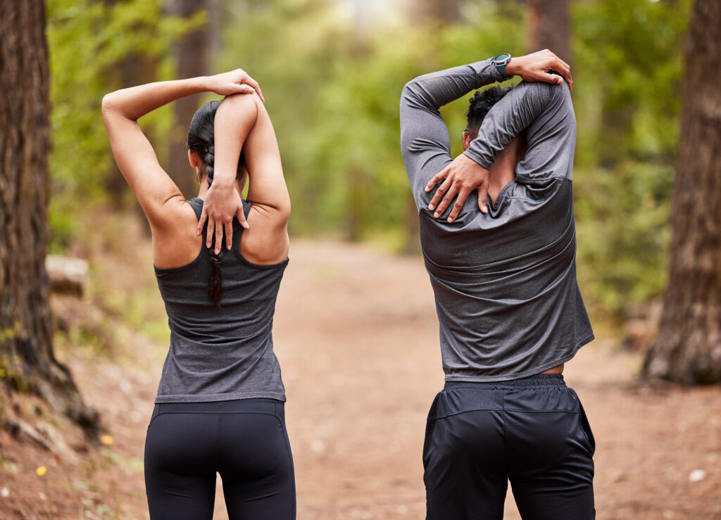 back, fitness and stretching with couple in forest for start of marathon, training or workout exercise, health and warm up with athlete or runner people in nature for cardio preparation together