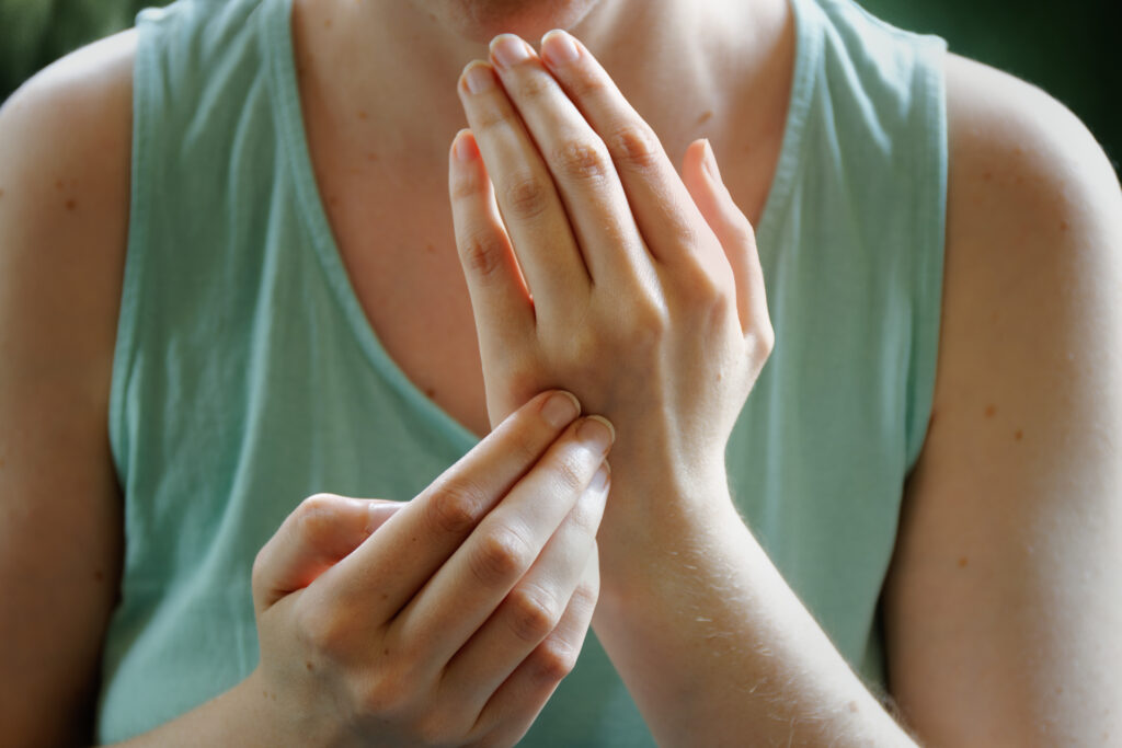 person practicing eft female tapping gamut point, hands close up view